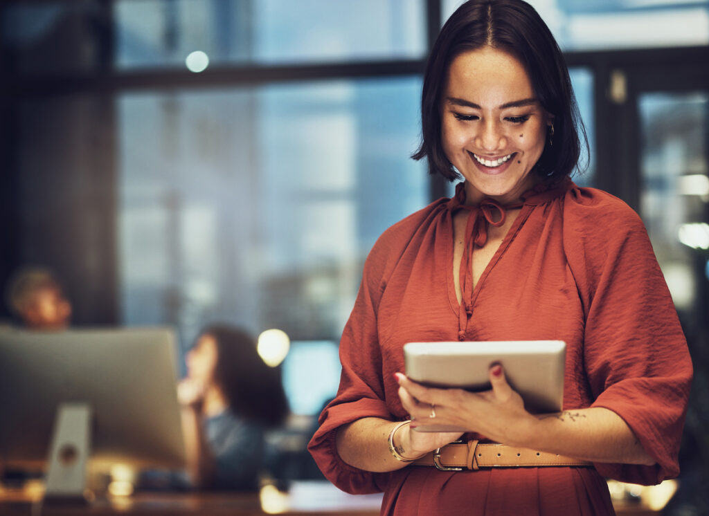 mulher segurando tablet em escritório de pé, representando a plataforma mdm
